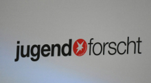 Das Logo des Schüler- und Jugendwettbewerbs «Jugend forscht» steht an einer Pressewand in Hamburg. Foto: David Hammersen/dpa