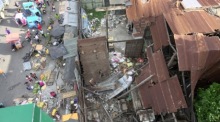 Filipinos neben einem eingestürzten Gebäude nach einem Erdbeben in General Santos City. Foto: epa/Cerilo Ebrano