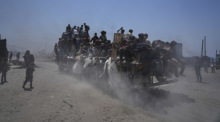 Palästinenser halten sich an einem Hilfstransporter fest, der aus dem nördlichen Gazastreifen nach Gaza-Stadt zurückkehrt. Foto: Abdel Kareem Hana/Ap/dpa