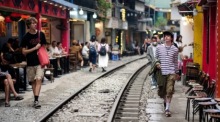 Touristen spazieren entlang der Bahnstrecke der berühmten „Train Street“ in Hanoi. Foto: epa/Luong Thai Linh