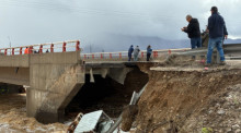 Ein Lastwagen befindet sich unter einer Brücke, nachdem er infolge eines Erdrutschs von der Maitencillo-Brücke in die Fluten gestürzt ist. Foto: Lucas Aguayo/Agencia Uno/dpa