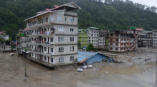 Gebäude sind vom Hochwasser nach einer Sturzflut umgeben. In der Nacht auf Mittwoch, 04.10.2023, hat Starkregen unter anderem den Wasserpegel des Flusses Teesta stark ansteigen lassen. Foto: Prakash Adhikari/Ap/dpa