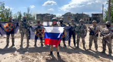 Spricht Jewgeni Prigoschin (M), der Chef des Militärunternehmens Wagner Group, mit einer russischen Nationalfahne in der Hand vor seinen Soldaten. Foto: Uncredited/Prigozhin Press Service/dpa