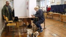 Eine Frau sitzt in einer Wahlkabine in einem Wahllokal während der Parlamentswahlen in Riga. Foto: epa/Toms Kalnins