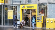 eine Frau betritt eine Postbankfiliale in Frankfurt am Main. Foto: epa/Armando Babani