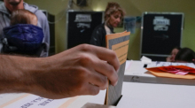 Ein Wähler steckt seinen Stimmzettel in eine Wahlurne in einem Wahllokal in Rom. Italien wählt am Sonntag, 25.09.2022 ein neues Parlament. Foto: Alessandra Tarantino/Ap/dpa