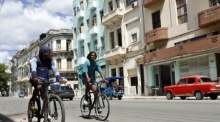 Menschen fahren mit Fahrrädern durch eine Straße in Havanna. Der Alltag in Kuba wird von den jüngsten Spannungen mit den USA überschattet. Foto: epa/Ernesto Mastrascusa