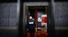 Ein französischer Polizeibeamter betritt den Gerichtssaal in Nantes zum Prozess gegen den als „Maskenmann“ bekannten Deutschen. Foto: AFP/dpa/loic Venance