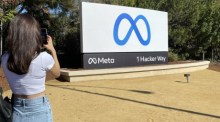 Eine Besucherin fotografiert ein Werbeschild mit dem neuen Logo und dem Namen "Meta" vor dem Facebook-Hauptquartier in Menlo Park. Foto: EPA-EFE/John G. Mabanglo