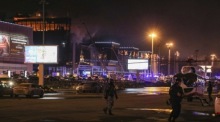Die russischen Polizisten und Beamten arbeiten in der Nähe des brennenden Konzertsaals Crocus City Hall. Foto: epa/Maxim Shipenkov