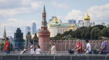 Eine russische Person läuft auf einer Brücke vor dem Kreml in Moskau. Foto: epa/Yuri Kochetkov