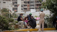 Menschen warten in einem vom Erdbeben betroffenen Gebiet in Catia La Mar in Venezuela. Foto: EPA/Ronald Peña R.