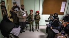 Taliban stehen neben zwei Jungen, die als Soldaten verkleidet sind, in einem Klassenraum einer Polizei-Kaserne in der Frauen zu Polizistinnen ausgebildet werden. Foto: Oliver Weiken/dpa