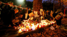 Trauernde Menschen zünden vor dem Bataclan Theater Kerzen an und legen Blumen nieder. Foto: Malte Christians/dpa