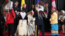 Papst Franziskus wird von Vertretern der Kanadischen Ureinwohner begrüßt. Das Oberhaupt der katholischen Kirche brach am Sonntag zu einer sechstägigen Reise nach Kanada auf. Foto: Johannes Neudecker/dpa