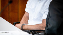 Der Angeklagte sitzt mit Handschellen in einem Gerichtssaal des Landgerichts Heilbronn auf seinem Platz. Foto: Christoph Schmidt/dpa