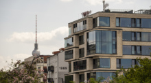 Hinter einem Gebäude mit Luxuswohnungen in Prenzlauer Berg ist der Fernsehturm zu sehen. Wenn es in Städten und Dörfern erst schöner, dann teurer wird - das kennen viele. Foto: Christophe Gateau/dpa