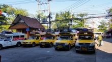 Gelbe Songthaew (Sammeltaxis) warten auf Kundschaft. Foto: DER FARANG/Rüegsegger