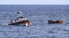 Mitglieder der Besatzung eines Bootes der italienischen Küstenwache ziehen zwei kleine Boote ab, in denen Migranten aus dem Meer gerettet wurden. Foto: epa/Ciro Fusco