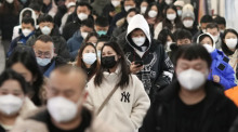 Menschen mit Mund-Nasen-Schutz gehen während der Hauptverkehrszeit durch eine U-Bahn-Station. Foto: Uncredited/Kyodo/dpa