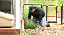 Ein Polizeibeamter sucht nach Spuren auf dem Grundstück von Erin Patterson in Leongatha, Victoria. Foto: James Ross/Aap/dpa