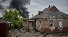 Ein Einheimischer sitzt in der Nähe seines beschädigten Hauses, aus dem nach dem Beschuss Rauch aufsteigt, am Stadtrand von Charkiw. Foto: epa/Sergey Kozlov