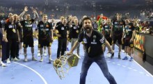 Der Magdeburger Cheftrainer Bennet Wiegert jubelt mit dem Pokal nach dem Sieg im Endspiel der EHF FINAL4 Handball Champions League. Foto: epa/Ronald Wittek
