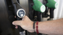 Ein Mann nimmt einen Zapfhahn an der Trigema-Tankstelle in Burladingen in die Hand. Foto: Marijan Murat/dpa