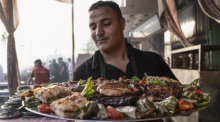 Ein Arbeiter bereitet in einem Restaurant in der Nähe des Bab al-Futuh, eines historischen Wahrzeichens in Kairo, das Essen für das Iftar während des heiligen Ramadan vor. Foto: Lobna Tarek/dpa