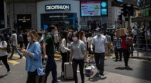 Personen tragen Gesichtsmasken, als sie eine Kreuzung in Central, Hongkong, überqueren. Foto: epa/Jerome Favre