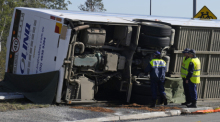 Die Polizei inspiziert einen Bus in der Nähe der Stadt Greta nach einem Unfall im Hunter Valley, nördlich von Sydney, Australien. Foto: Mark Baker/Ap/dpa