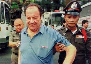 Wolfgang Ullrich, begleitet von thailändischen Polizeibeamten, wird in Bangkok zu einer Vernehmung gebracht. Das war vor rund drei Jahren. Jetzt muss der Deutsche wegen Untreue zwölf Jahre in Haft.