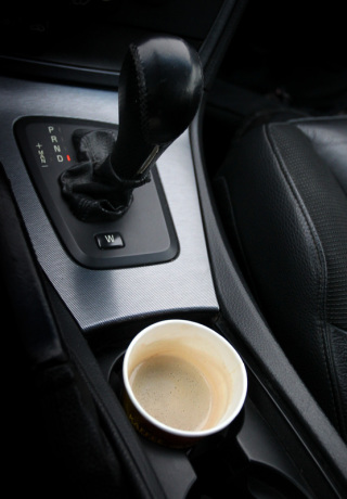 Ein Pappbecher mit Kaffee steht in einem Automatik-Auto. Foto: Karl-Josef Hildenbrand/Dpa