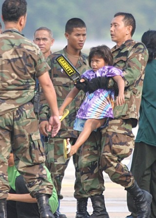 Soldaten nehmen ein bettelndes Mädchen mit nur einem Bein mit. Das Kind wird später nach Kambodscha transportiert.
