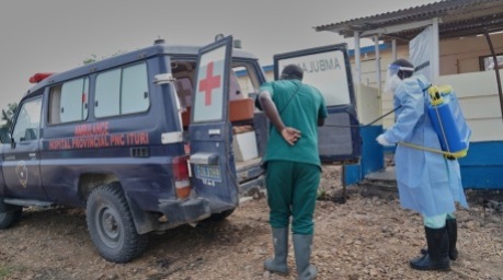 Mitarbeiter des Gesundheitswesens desinfizieren im ostkongolesischen Rwampara ein Ambulanzfahrzeug, das zum Transport von Ebola-Patienten eingesetzt wird. Foto: Dieudonne Dirole/epa/dpa.