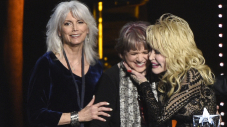 Dolly Parton wird bei ihrer Ehrung zur „MusiCares Person of the Year“ von Emmylou Harris und Linda Ronstadt umarmt. Foto: Chris Pizzello/Invision/ap/dpa