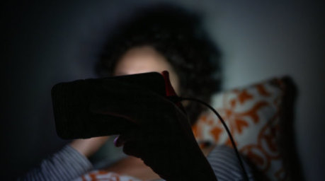 Eine Frau schaut im Bett eine Sendung auf dem Smartphone. Foto: Sebastian Gollnow/dpa/dpa-tmn