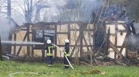 Feuerwehrleute löschen in Wüstefeld bei Rotenburg die noch rauchenden Trümmer des ehemaligen Hofes des «Kannibalen von Rotenburg». Foto: Boris Roessler/dpa