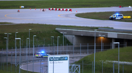Klimaaktivisten haben sich am frühen Morgen auf einer Zufahrt für Start- und Landebahnen am Flughafen Franz-Josef-Strauß festgeklebt. Foto: Karl-Josef Hildenbrand/dpa