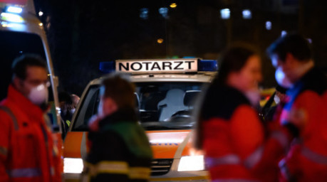«Notarzt» steht auf einem Fahrzeug der Feuerwehr, vor dem sich mehrere Einsatz- und Rettungskräfte besprechen. Foto: Jonas Walzberg/dpa