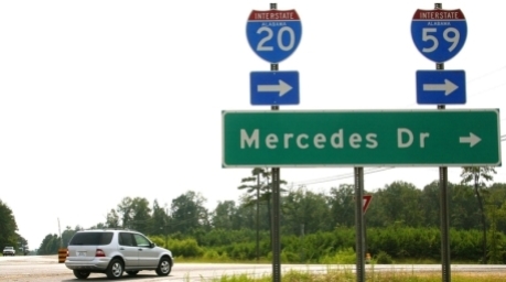 in Mercedes der M-Klasse biegt hinter einem Straßen-Schild zum Mercedes-Werk ab. Foto: Harry Melchert/dpa