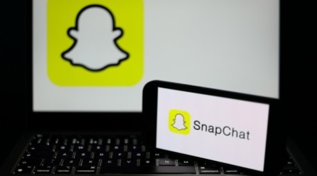 Das Logo der Social-Media-App Snapchat ist auf einem Smartphone und einem Laptop zu sehen. In Großbritannien wird über strengere Alterskontrollen für soziale Netzwerke diskutiert. Foto: Adam Vaughan/epa/dpa.