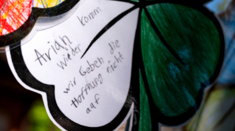 Ein gebasteltes Kleeblatt mit der Aufschrift „Arian komm wieder. Wir geben die Hoffnung nicht auf“ hängt an einem Zaun. Foto: Daniel Bockwoldt/dpa