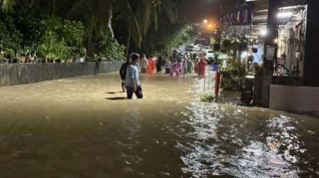 Bild 1: Bewohner waten in der Nacht durch überflutete Straßen, nachdem starke Regenfälle mehrere Gemeinden im Süden Thailands unter Wasser gesetzt hatten. Bild: DDPM