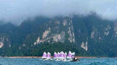 Teilnehmer der Segelregatta steuern ihre Optimist-Jollen vor der markanten Karstkulisse des Ratchaprapha-Stausees in Surat Thani. Bild: JS100 Radio