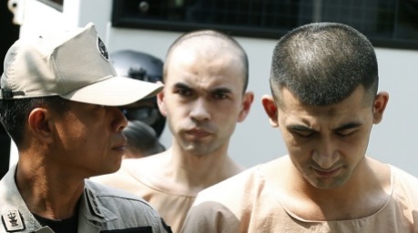 Die mutmaßlichen Erawan-Anschlagsverdächtigen Yusufu Mieraili (r.) und Adem Karadag (M.) werden von Polizisten und Justizvollzugsbeamten eskortiert. Foto: epa/Narong Sangnak