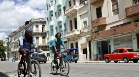 Menschen fahren mit Fahrrädern durch eine Straße in Havanna. Der Alltag in Kuba wird von den jüngsten Spannungen mit den USA überschattet. Foto: epa/Ernesto Mastrascusa