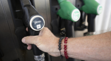 Ein Mann nimmt einen Zapfhahn an der Trigema-Tankstelle in Burladingen in die Hand. Foto: Marijan Murat/dpa