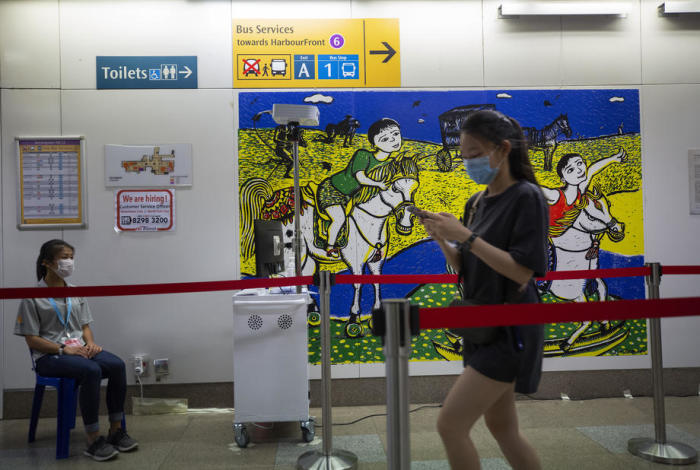 Ein Sicherheitsbeauftragter (L) kontrolliert die Temperatur von Personen, die eine Mass Rapid Transit (MRT)-Station in Singapur betreten. Foto: epa/How Hwee Young