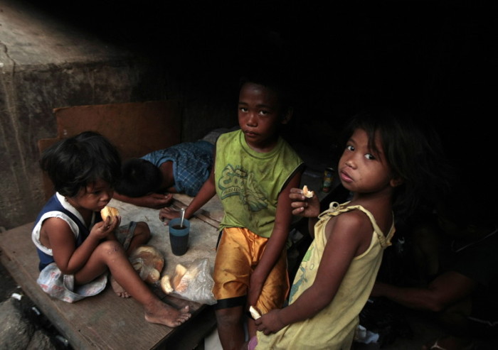 Philippinische Kinder, die unter einer Brücke wohnen, essen Brot in der Stadt Paranaque, südlich von Manila. Foto: epa/Francis R. Malasig